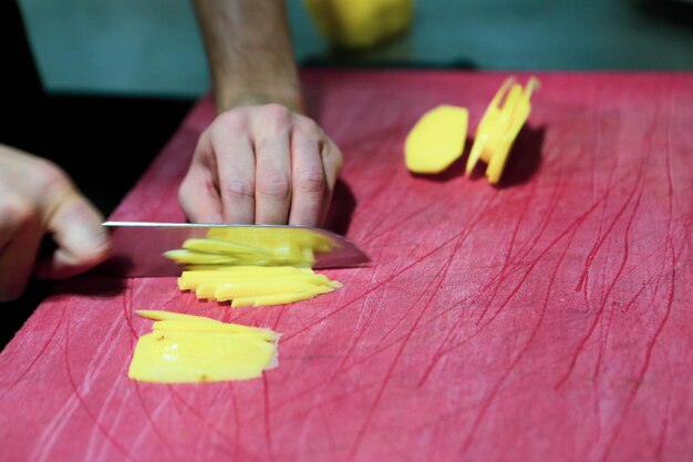 Homem corta as batatas para cozinhar