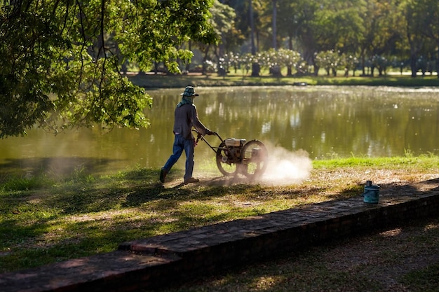 Homem cortando grama em dia de verão