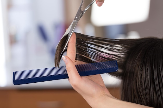 Homem cortando o cabelo com uma tesoura no fundo, close-up