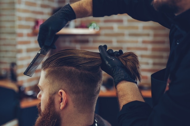 Homem cortando o cabelo da moda na barbearia