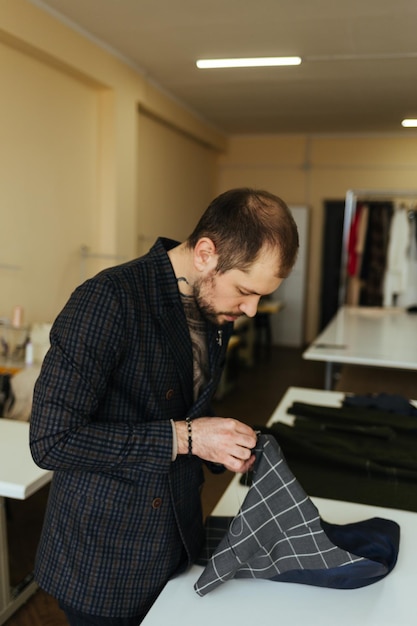 Foto homem costura um botão para sua camisa