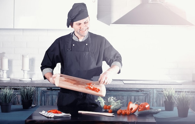 Homem cozinheiro preparando comida na cozinha de legumes