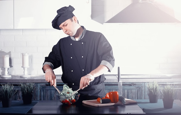 Homem cozinheiro preparando comida na mesa da cozinha de legumesxA