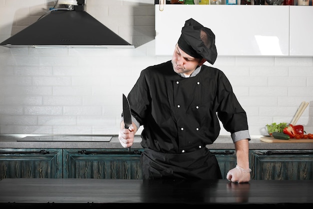 Homem cozinheiro preparando comida na mesa da cozinha de legumesxA