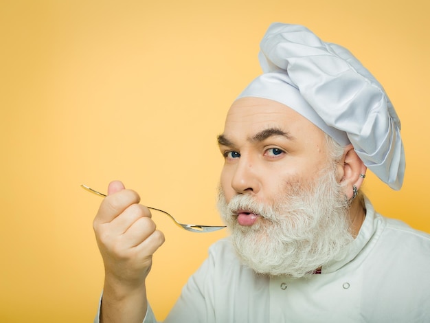 Homem cozinheiro prova comida