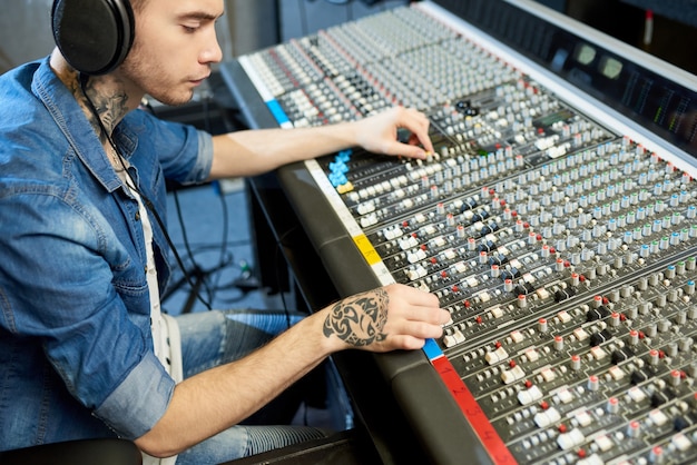 Foto homem criando música no estúdio de gravação