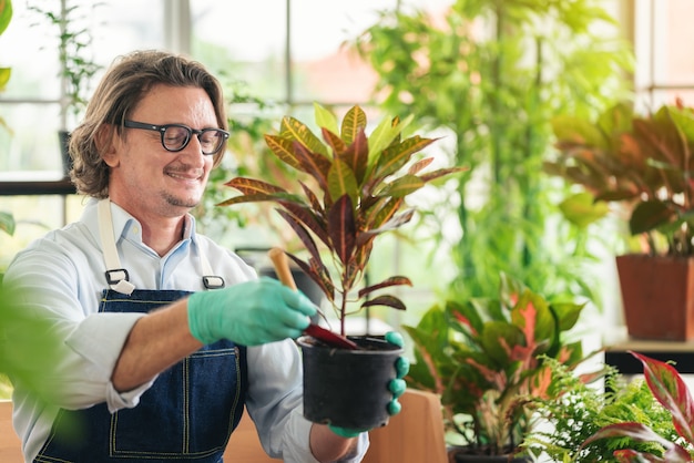 Homem cuidando de seus vasos de plantas em casa, jardinagem, plantando em casa