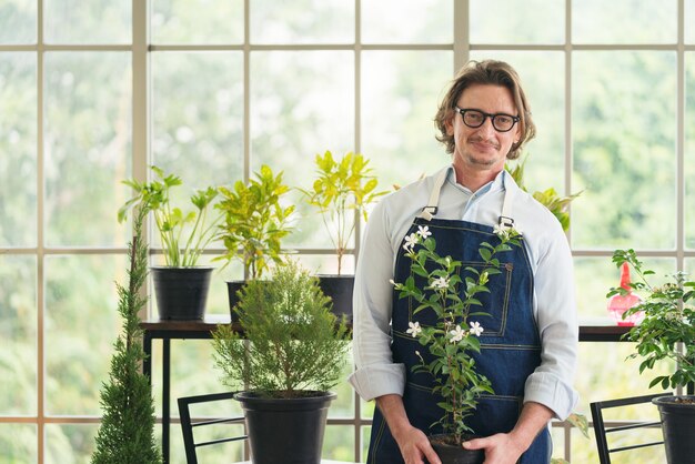 Homem cuidando de seus vasos de plantas em casa, jardinagem, plantando em casa