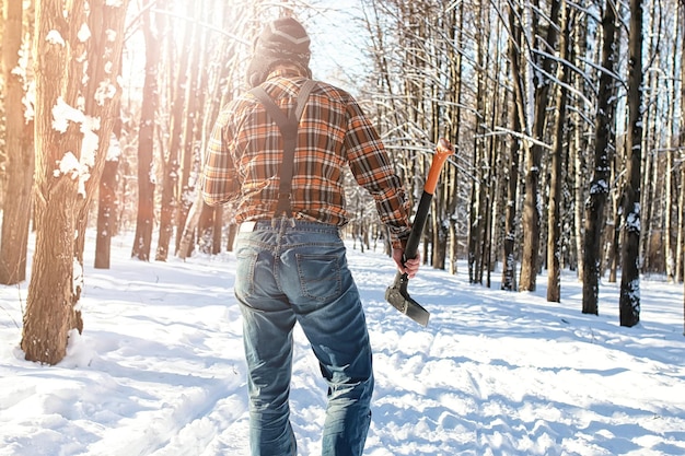 Homem da floresta de inverno de vidoeiro com machado