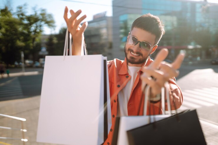 Foto homem da moda com sacolas de compras andando na rua compras de venda de consumismo compras
