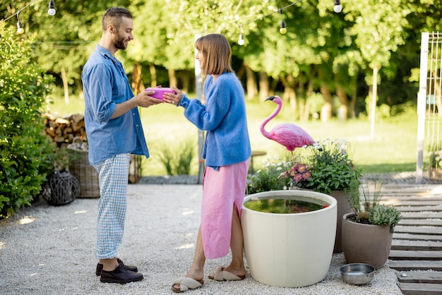 Homem dá um presente na caixa rosa para sua mulher comemorando ao ar livre