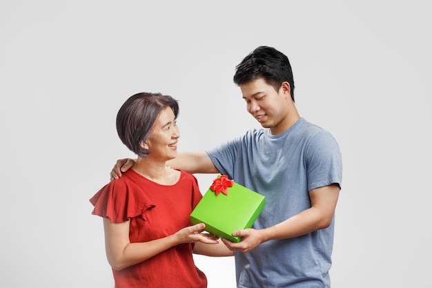 Homem dando um presente para sua mãe