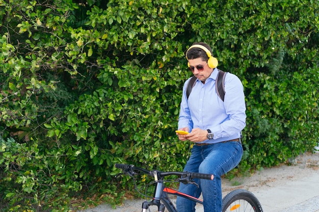 Homem de 40 anos ouvindo música no celular enquanto andava de bicicleta