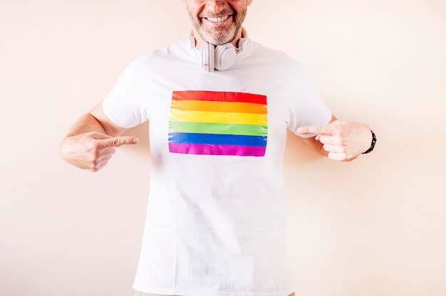 Homem de 45 anos vestindo uma camiseta branca com a bandeira do orgulho