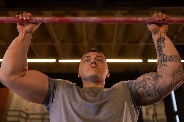 Foto homem de ajuste de ângulo baixo treinando na academia