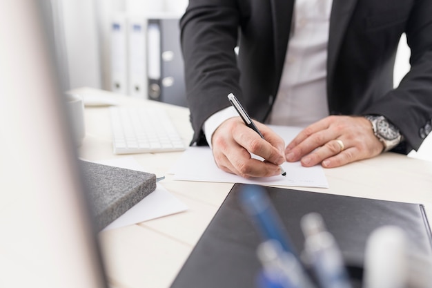 Homem de alto ângulo, escrevendo algo para o trabalho