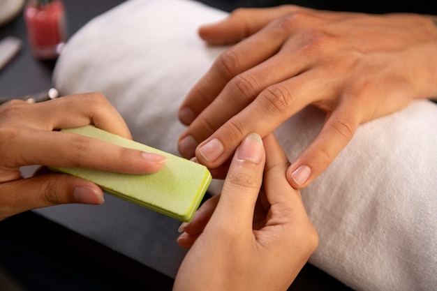 Foto homem de alto ângulo fazendo manicure