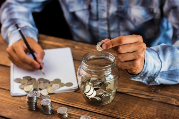 Homem de ângulo alto que calcula economias