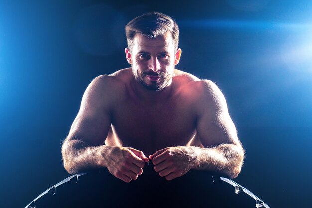 Homem de aptidão muscular estátua antiga músculos perfeitos seis pack abs e fisiculturista de peito nu, lançando a roda do pneu em um fundo preto no estúdio. Ginásio de treino de treino funcional de conceito