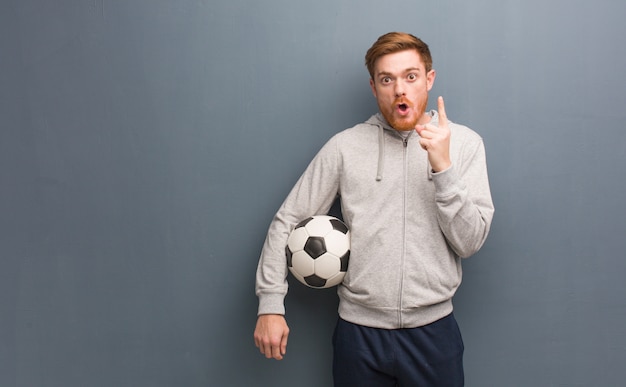 Homem de aptidão ruiva jovem tendo uma ótima idéia