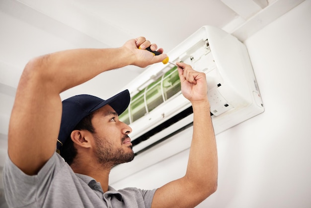 Homem de ar condicionado e reparo de máquina elétrica com pessoa em uma casa com caixa AC Chave de fenda de manutenção e controle do sistema para inspeção de instalação de conserto de ar condicionado em casa com empreiteiro