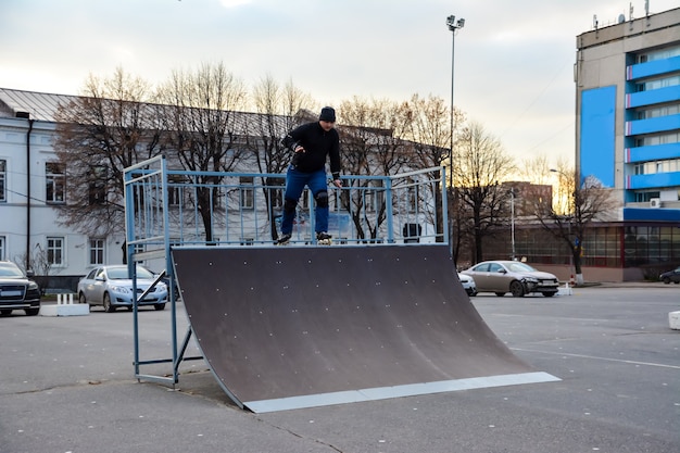 Homem de atividade de lazer patinação no centro da cidade, no pôr do sol. inverno. patinação de rua.