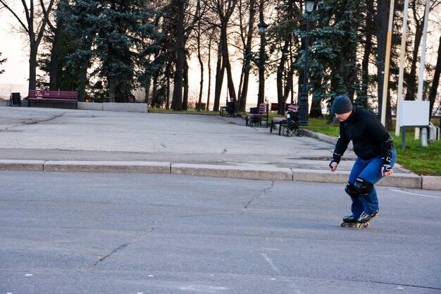 Homem de atividade de lazer patinação no centro da cidade, no pôr do sol. inverno. patinação de rua.