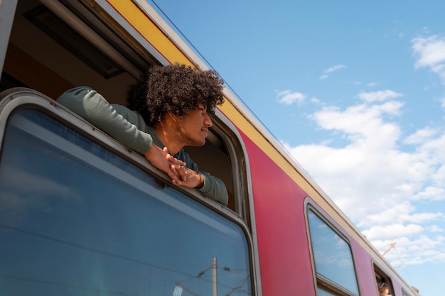 Foto homem de baixo ângulo viajando de trem