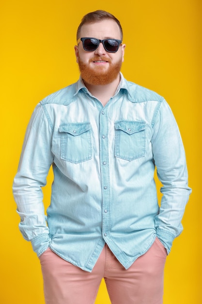 Homem de barba em óculos de sol e camisa jeans