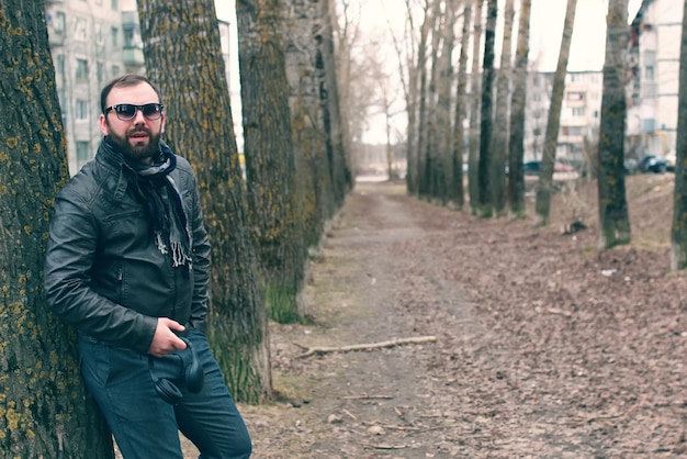 Homem de barba no parque com fone de ouvido