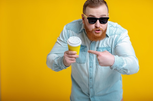 Homem de barba ruiva segurando xícara com café