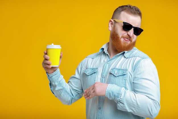 Homem de barba ruiva segurando xícara com café