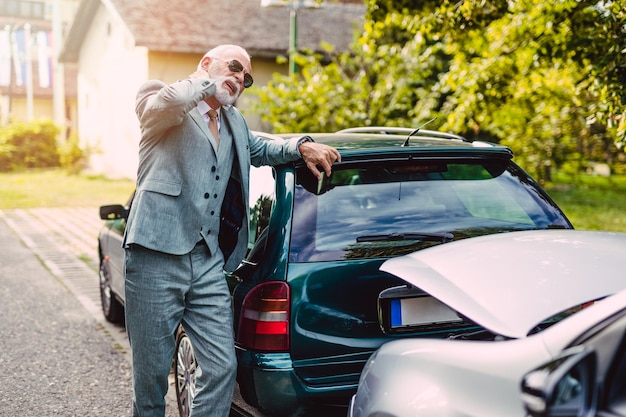 Homem de barba sênior ferido após acidente de carro ruim.