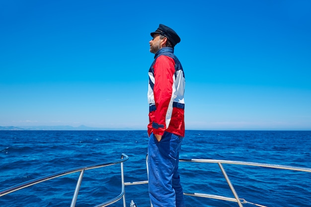 Foto homem de boné de marinheiro de barba navegando mar oceano em um barco