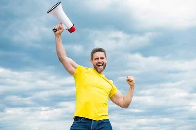 Homem de camisa amarela com megafone no fundo do céu última chance