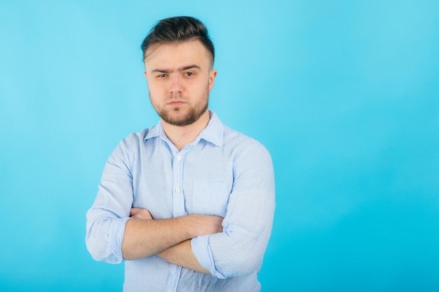 homem de camisa azul com as mãos postas fica em fundo azul