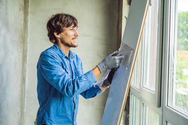 Homem de camisa azul faz instalação de janela