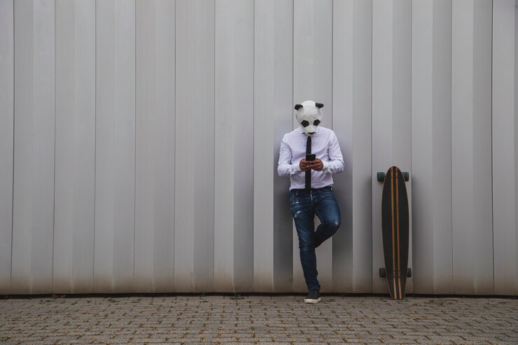 Foto homem de camisa branca, gravata e máscara de urso panda conversando com um smartphone. espaço para texto