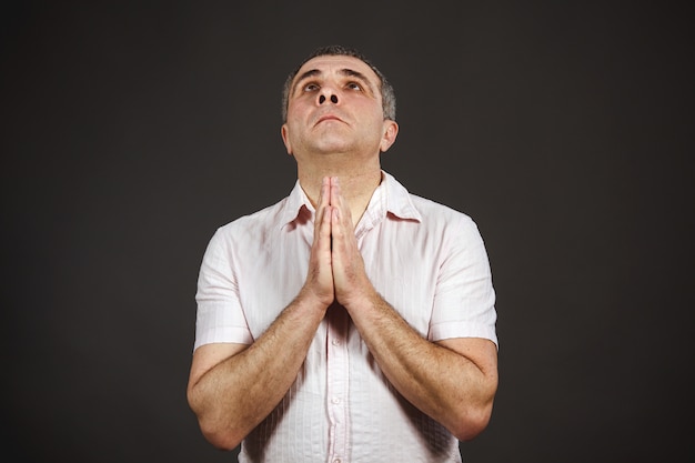 Foto homem de camisa branca rezando
