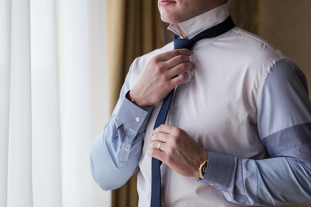 homem de camisa, vestir-se e ajustar a gravata no pescoço em casa