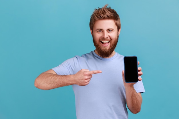 Homem de camiseta apontando o dedo para smartphone com espaço de cópia de tela em branco preto para propaganda