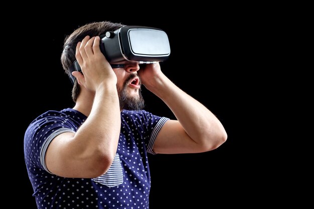 Homem de camiseta azul pontilhada usando realidade virtual 3d-fone de ouvido