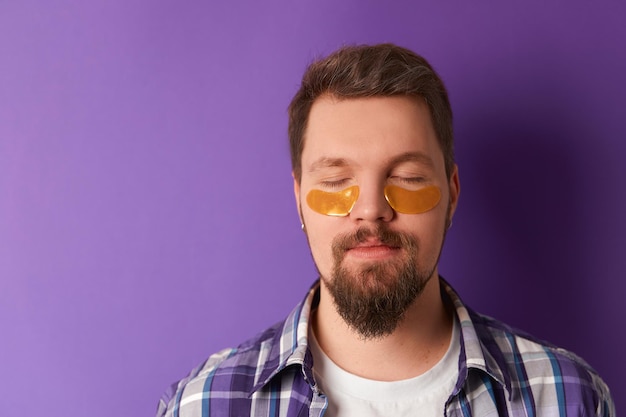 Homem de camiseta branca com tapa-olhos contra fundo violeta tratamento de beleza spa bem-estar