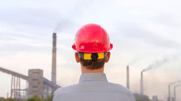 Homem de capacete no fundo da planta