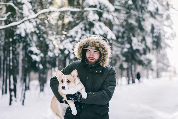 Homem de casaco de inverno passeando com seu cachorro