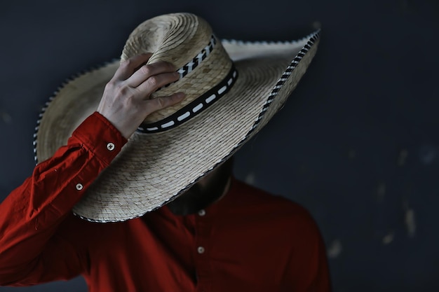 Foto homem de chapéu com aba de palha, esconde o rosto, cara incógnito, estilo abstrato de música country américa oeste