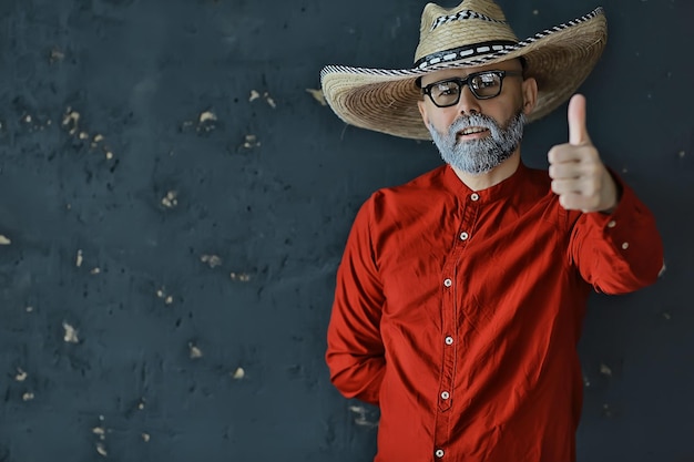 homem de chapéu de palha com aba nos gestos de estúdio com as mãos e os dedos, pontos. estilo sambrero da américa ocidental méxico