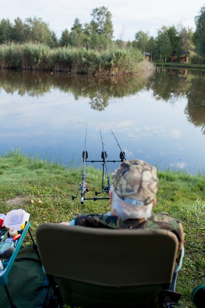 Homem de chapéu de pesca em um lago