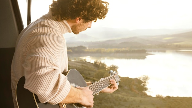 Foto homem de close tocando violão