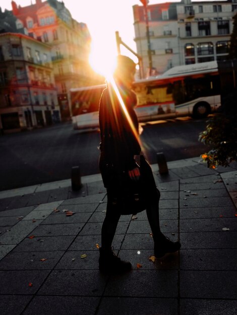 Homem de comprimento completo na rua da cidade durante o pôr-do-sol